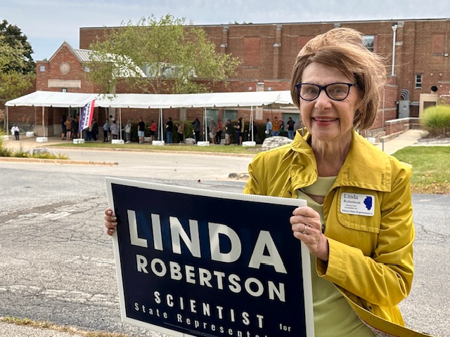 Linda Robertson holding a campaign sign